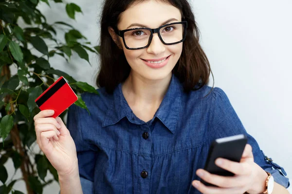 woman  holding credit card and phone