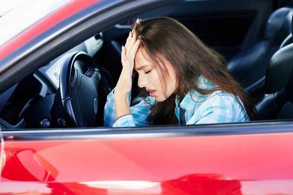 Naštvaná žena jízdy červené auto — Stock fotografie