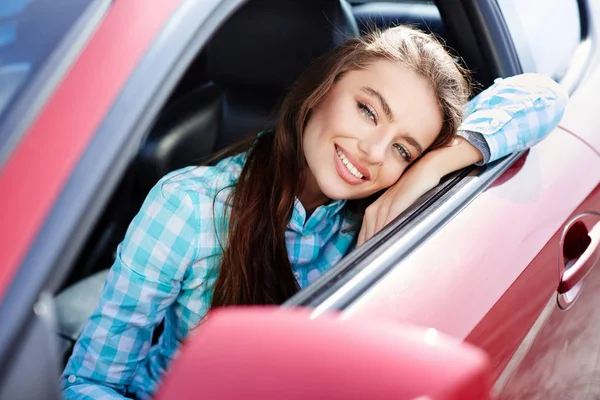 Žena sedí uvnitř červené auto — Stock fotografie