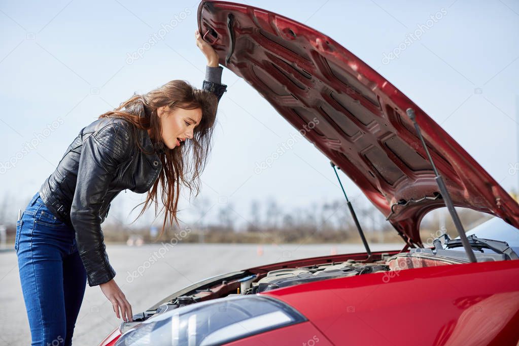 woman looking inside of broken car
