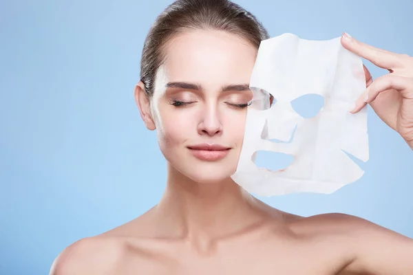 Vrouw verwijderen masker uit gezicht — Stockfoto