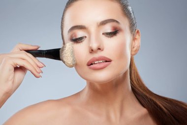 Güzel kız makyaj fırça kullanarak