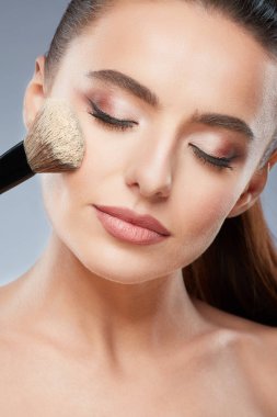 Güzel kız makyaj fırça kullanarak
