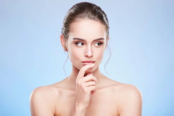 Mujer tocando el labio inferior y mirando a un lado astutamente — Foto de Stock