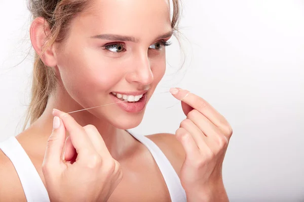 Mooie vrouw met behulp van tanden draad — Stockfoto