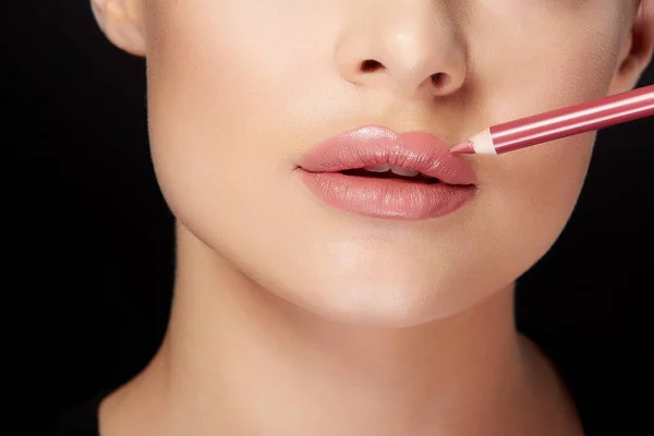 Mujer joven pintando labios con lápiz de labios rojo — Foto de Stock