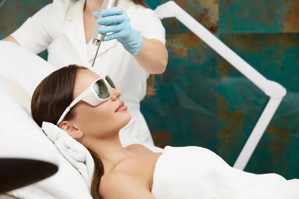 Bella donna che riceve il trattamento viso con laser nel salone di bellezza da estetista — Foto Stock