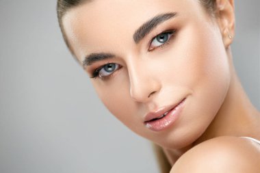 Çekici, zarif bir kadın yüzü, mükemmel bir teni ve güzel bir gülümsemesi var.