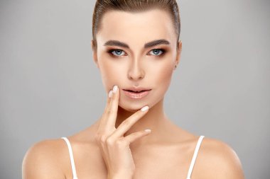 Açık akşam makyajlı zarif kadın portresi gri renkte izole edilmiş.