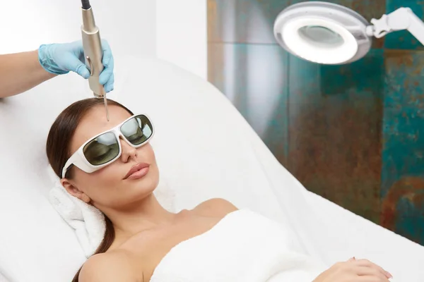 Kobieta Leżąca Klinice Dermatologicznej Kosmetyczka Trzymająca Laser Czole Depilacja Specjalnym — Zdjęcie stockowe
