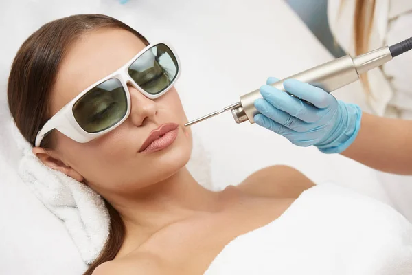 顔の保護メガネのためのレーザー治療を受けて美しい女性のクローズアップ 顔の手順を有する美容クリニックの女性の顧客 — ストック写真