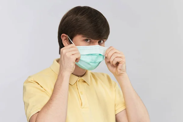 年轻人用无菌即弃口罩保护脸部免受病毒和污染 — 图库照片