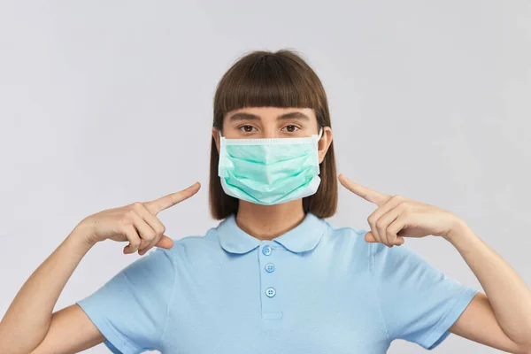 Young Serious Girl Wearing Protection Sterile Mask Poiting Fingers Protection — Stock Photo, Image