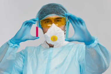 Değişik renkli biyolojik tehlike test tüpleriyle erkek kimyager.