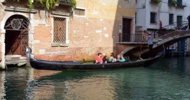 VENICE, İtalya - 26 Haziran 2014: Turistler İtalya 'nın Venedik Kanalı' nda gondolla seyahat ederler. Gondol gezisi Venedik 'teki en popüler turistik etkinliktir..