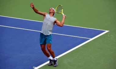 Sahada tenis oynayan adam.