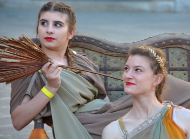 PULA CROATIA 05 22 2019: Roma 'nın en iyi amfiaterlerinden Pula Arena olarak bilinen antik Roma binalarının sayıları ile bilinen Pula şehrinde turistler için Romalı rahibe gibi giyinmiş kadınlar