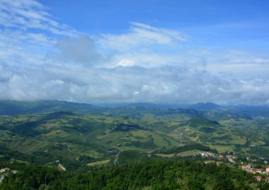 Tepelerin manzaralı panoramik manzarası bulutlu mavi gökyüzü yeşil yuvarlanan tepeler ve sabah güneşi