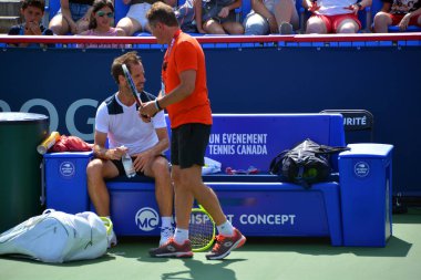 Sahada tenis oynayan adam.