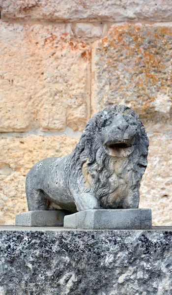 statue of a lion on the stone wall