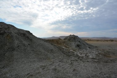 Azerbaycan 'daki Qobustan Ulusal Parkı' ndaki manzara. Çöl manzarası ve mavi gökyüzünün arka planındaki çamur volkanlarının zirveleri.. 