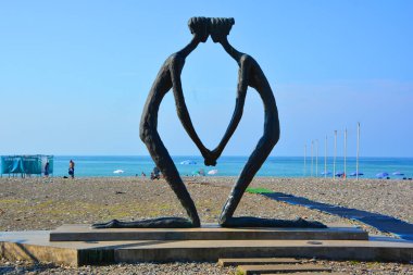 Genç kadın plajda yoga yapıyor.