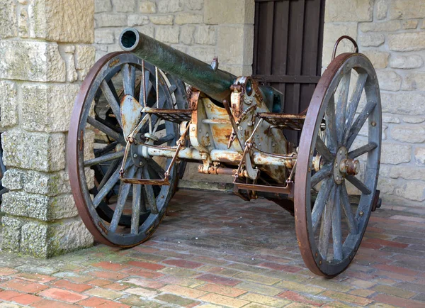 old gun near brick building