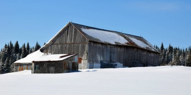 Karlı tepedeki tarihi Steamboat Springs ambarı. Kayak alanı kaldırımları ve arka planda yamaçları var.