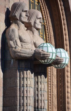 Helsinki Finlandiya 25 Eylül 2015: Helsinki Merkez Tren İstasyonu 'nda küresel lambaları tutan heykeller, Helsinki' nin merkezinin bir parçası olan Kluuvi 'de yaygın olarak tanınan bir simgedir.