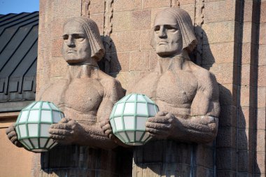 Helsinki Finlandiya 25 Eylül 2015: Helsinki Merkez Tren İstasyonu 'nda küresel lambaları tutan heykeller, Helsinki' nin merkezinin bir parçası olan Kluuvi 'de yaygın olarak tanınan bir simgedir.
