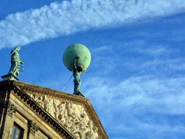 AMSTERDAM NETHERLANDS 10 03 2015: Atlas Carrying the Globe Statue on Royal Palace in Amsterdam  is one of three palaces in the Netherlands which are at the disposal of the monarch by Act of Parliament