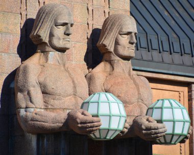 Helsinki Finlandiya 25 Eylül 2015: Helsinki Merkez Tren İstasyonu 'nda küresel lambaları tutan heykeller, Helsinki' nin merkezinin bir parçası olan Kluuvi 'de yaygın olarak tanınan bir simgedir.