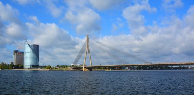 RIGA LATVIA SEPTEMBER 18 2015: The Vansu Bridge in Riga is a cable-stayed bridge that crosses the Daugava river in Riga and Swedbank office building sheer height and sleek silhouette. 