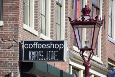 Amsterdam Hollanda 10. 03 2015: Kenevir kahve dükkanının işareti Hollanda 'da halk tarafından kişisel tüketim için esrar satışının yerel yetkililer tarafından tolere edildiği kurumlardır.