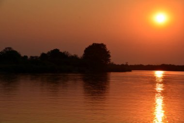 Sakin su yüzeyi üzerinde renkli günbatımı.