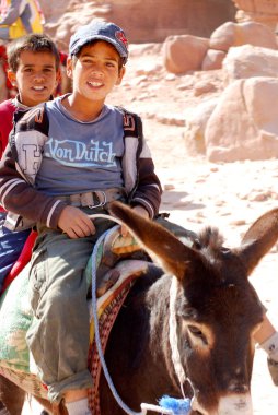 PETRA-JORDAN NOV 25: 25 Kasım 2009 Petra, Ürdün 'de deveye binen kimliği belirsiz çocuk. Yolculuk 20JD tuttu. Petra, Nabataean krallığının etkileyici başkentiydi..