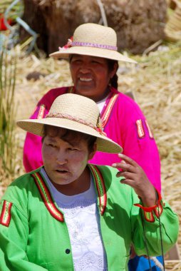 PUNO, PERU - NOV 28: Geleneksel elbiseli tanımlanamayan kadınlar Uros Adası, Puno, Peru, NOV. 28 'de turistleri karşıladı. 2010.Uro 'lar 42 kendi kendine yüzen adada yaşayan İnka öncesi insanlardır.