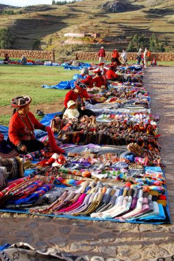 NEAR CUSCO PERU-NOVEMBER 15:Quechua women dressed in traditional clothing sale colorful tablecloths and fabric on November 15, 2010 in Cusco Peru. The national rural poverty rate is over 50 per cent.