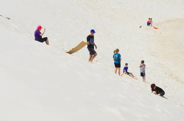 WHITE SANDS NM USA APRIL 24: People slide on sand at the White Sands National Monument  the largest gypsum dune field in the world. On april 24 2104 in White Sands NM USA