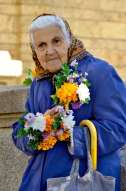 SOFIA BULGARIA SEPTEMBER 22: Old woman selling flowers for help to live in front the St Nedelya Church on september 22 2013 in Sofia Bulgaria