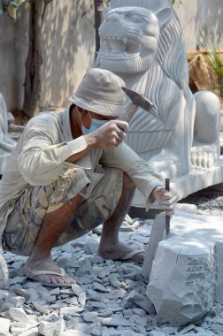 26 Mart 2013 'te Kampong Thum Kamboçya' da bir heykel oymak için mermer bloğa yontulmuş bir keski kullanan bir oymacı..