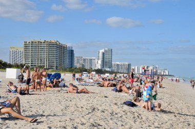 İnsanlar deniz sahilinde dinleniyor.