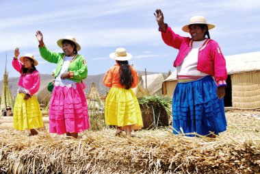 PUNO, PERU - NOV 28: Geleneksel elbiseli tanımlanamayan kadınlar Uros Adası, Puno, Peru, NOV. 28 'de turistleri karşıladı. 2010.Uro 'lar 42 kendi kendine yüzen adada yaşayan İnka öncesi insanlardır.