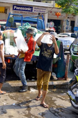 PHEN CAMBODIA - 26 Mart 2013 'te Phnom Phen Kamboçya' da genç adam pazara buz getirdi. Kamboçya 'da soğutma eksikliğinden dolayı, buz merkezi olarak üretilir..