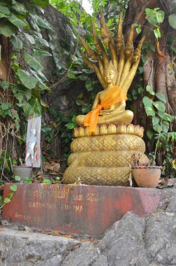 LUANG PRABANG LAOS - 3 Nisan 2013 'te Luang Prabang Laos' taki Phousi Dağı 'ndaki Wat Tham Phousi tapınağında Buda. Luang Prabang 'ın en iyi çekimlerinden biri..