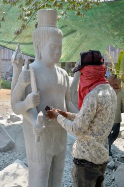 KAMPONG THUM CAMBODIA - 26 Mart 2013 'te Kampong Thum Kamboçya' da bir heykel oymak için misket keskisi kullanan bir oymacı.