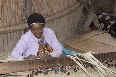 MANZINI, SWAZILAND - 25 Kasım 2010 Manzini, Svaziland 'da yaşamak için tanımlanamayan kadın samandan halı yapıyor