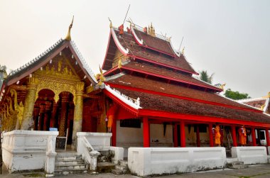 LUANG PRABANG LAOS - 31 Mart 2013 'te Lao nüfusunun% 96' sının inancı olan Luang Prabang Laos Budizmi 'nde çatılarını yeniden boyamak ve pagodalarını yeniden boyamak için çalışan keşiş.