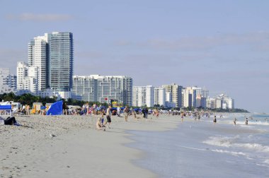 İnsanlar deniz sahilinde dinleniyor.