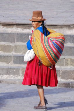 CUZCO PERU NOVEMBER 21: Cuzco Peru 'da 21 Kasım 2009' da plaza de armas 'da yaşamak için satılık hatıra eşyaları taşıyan tipik giysili kadın ulusal yoksulluk oranı yüzde 50' nin üzerinde.